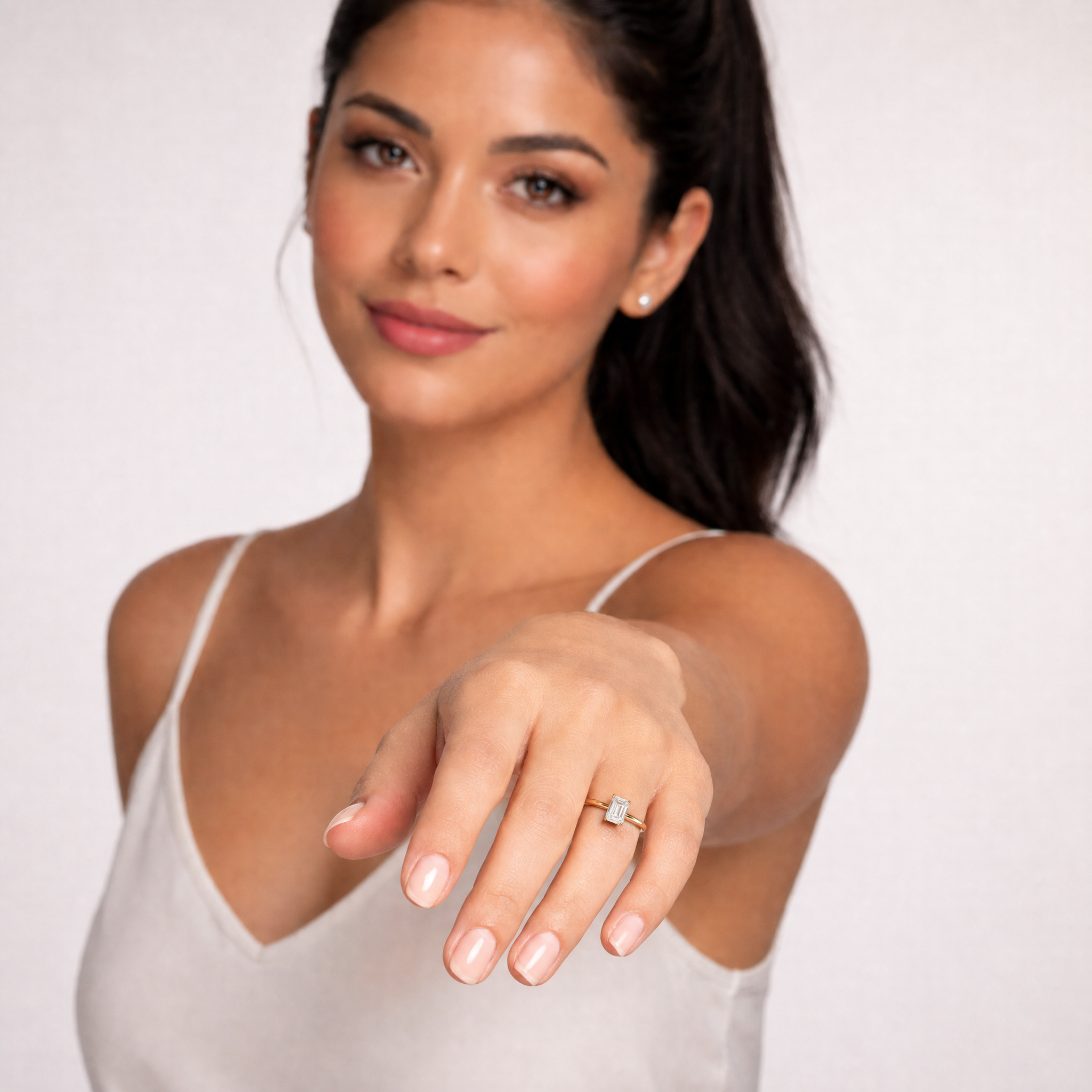 Sophisticated model Celeste showcasing a Raul Diamonds emerald cut hidden halo ring, highlighting the elongated step-cut diamond and elegant compass prong setting