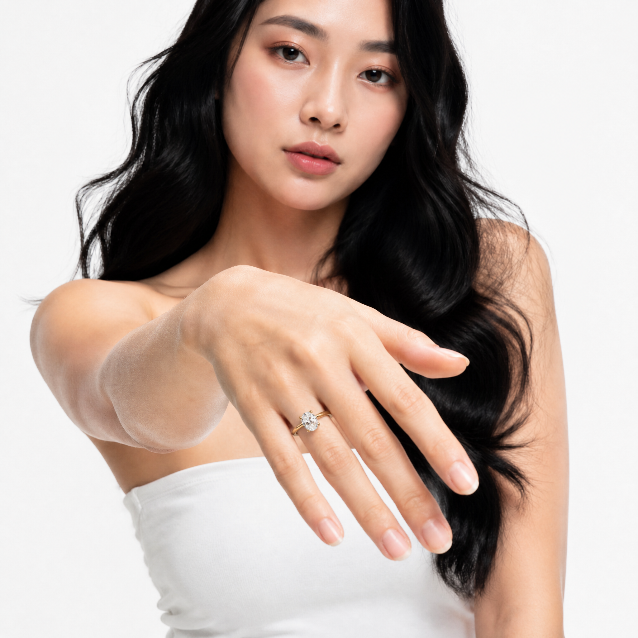 Elegant model Sophia showcasing a Raul Diamonds oval cut engagement ring with a hidden halo, highlighting the finger-elongating effect and high-profile compass prong setting
