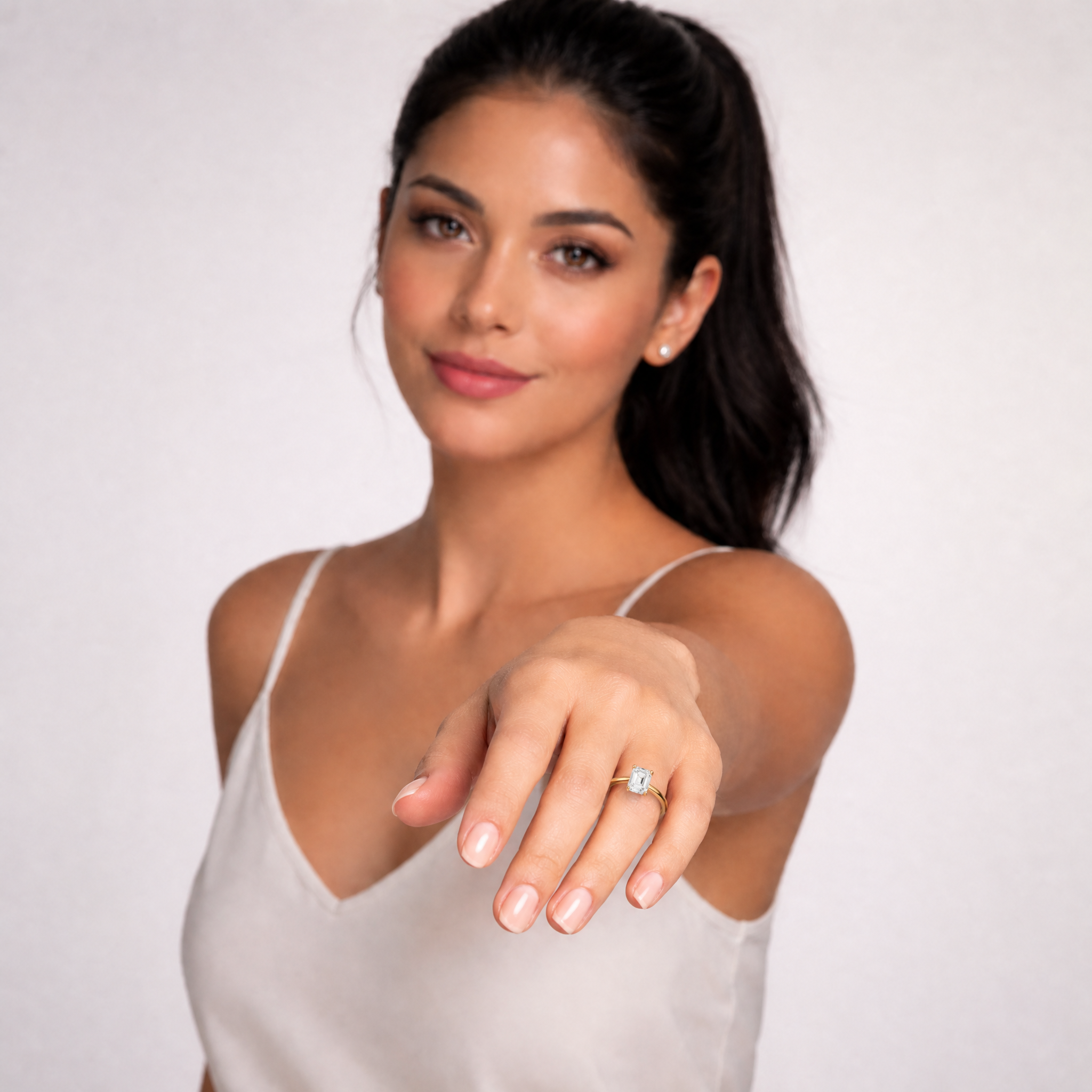 Elegant model Maya wearing a Raul Diamonds Asscher cut hidden halo ring, highlighting the ring's high-profile compass prong setting and brilliant clarity