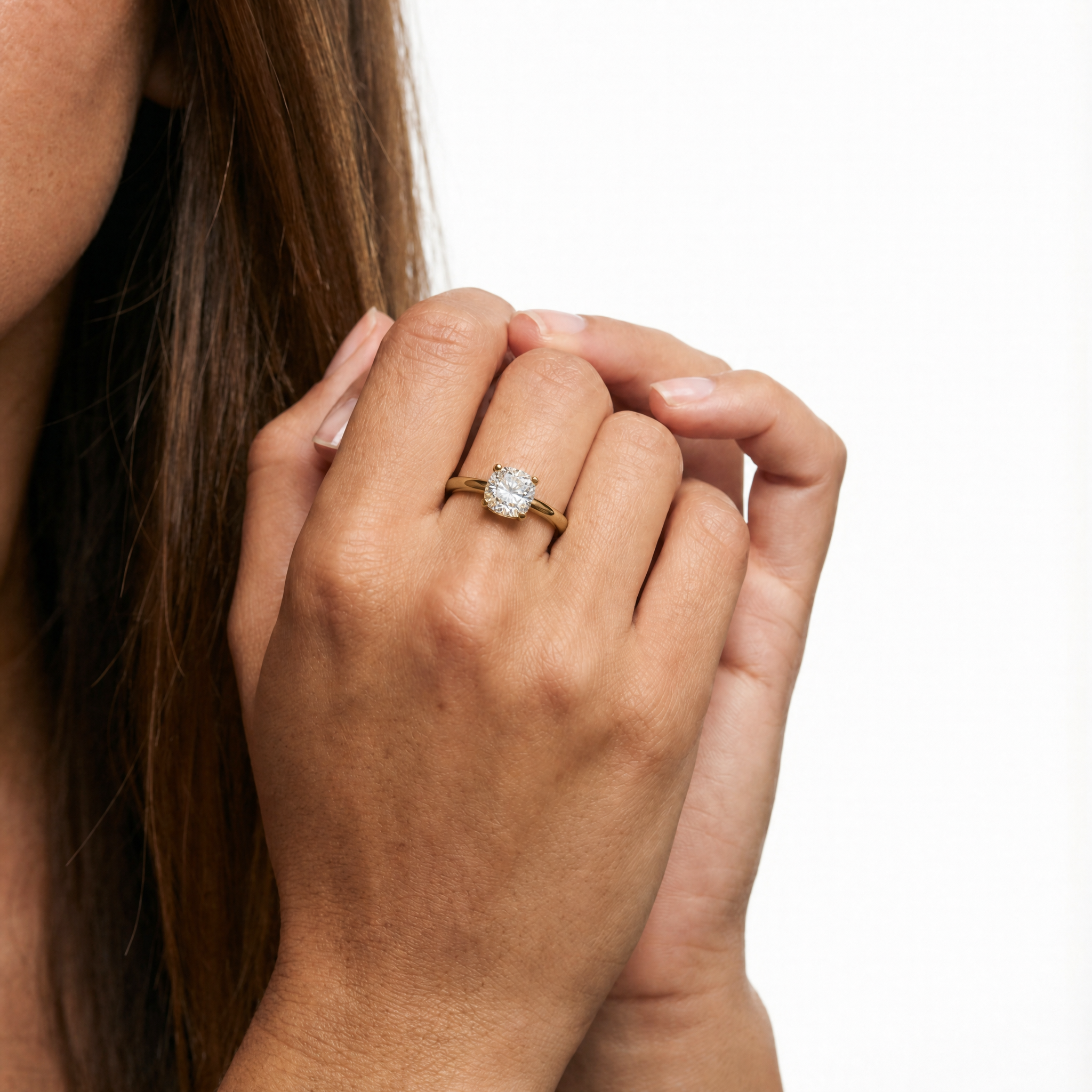 Hand model Seraphina wearing a Raul Diamonds cushion cut engagement ring with a hidden halo, showcasing the elegant high-set compass prongs and brilliant sparkle