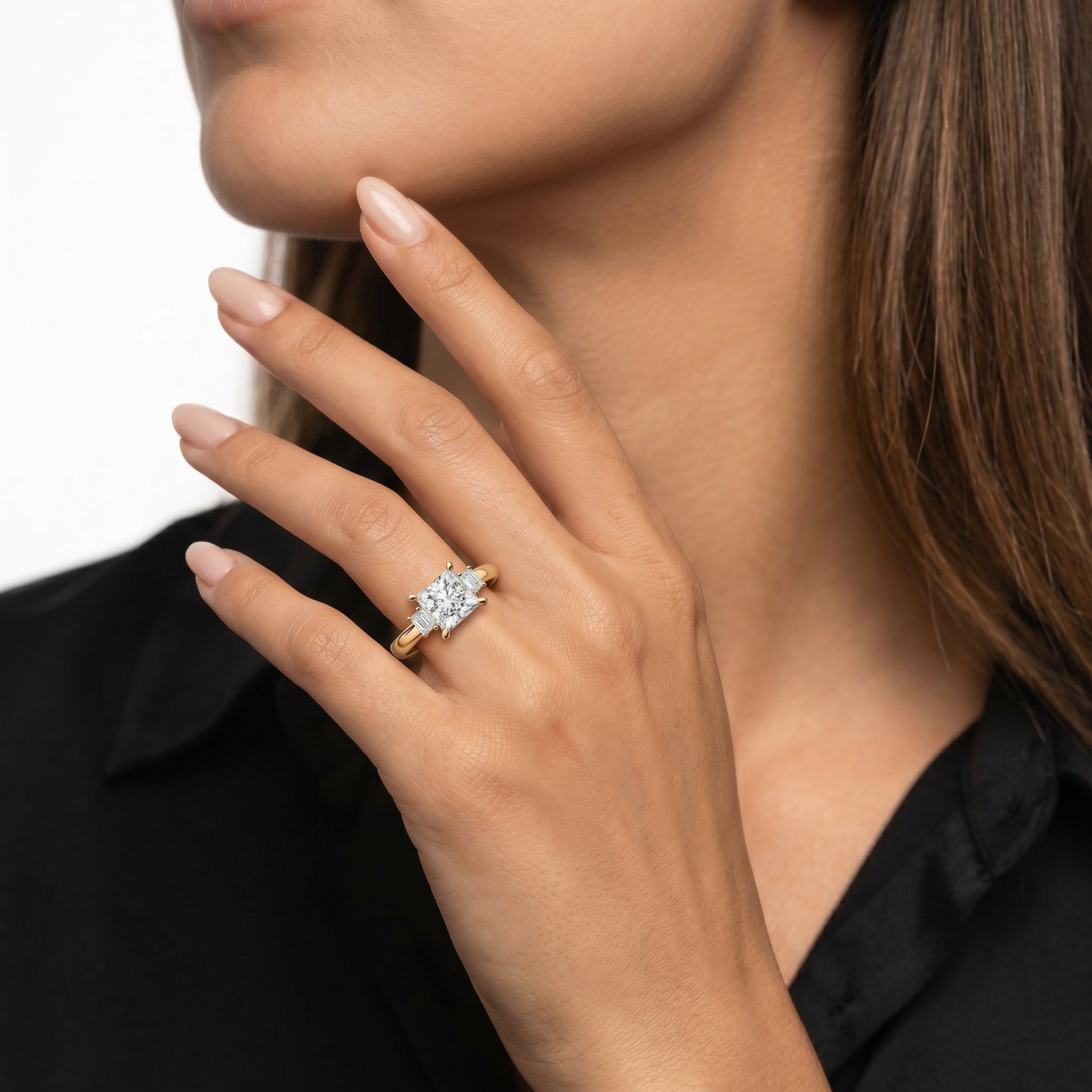 Model wearing an Asscher cut lab grown diamond three stone engagement ring in 14K gold by Raul Diamonds