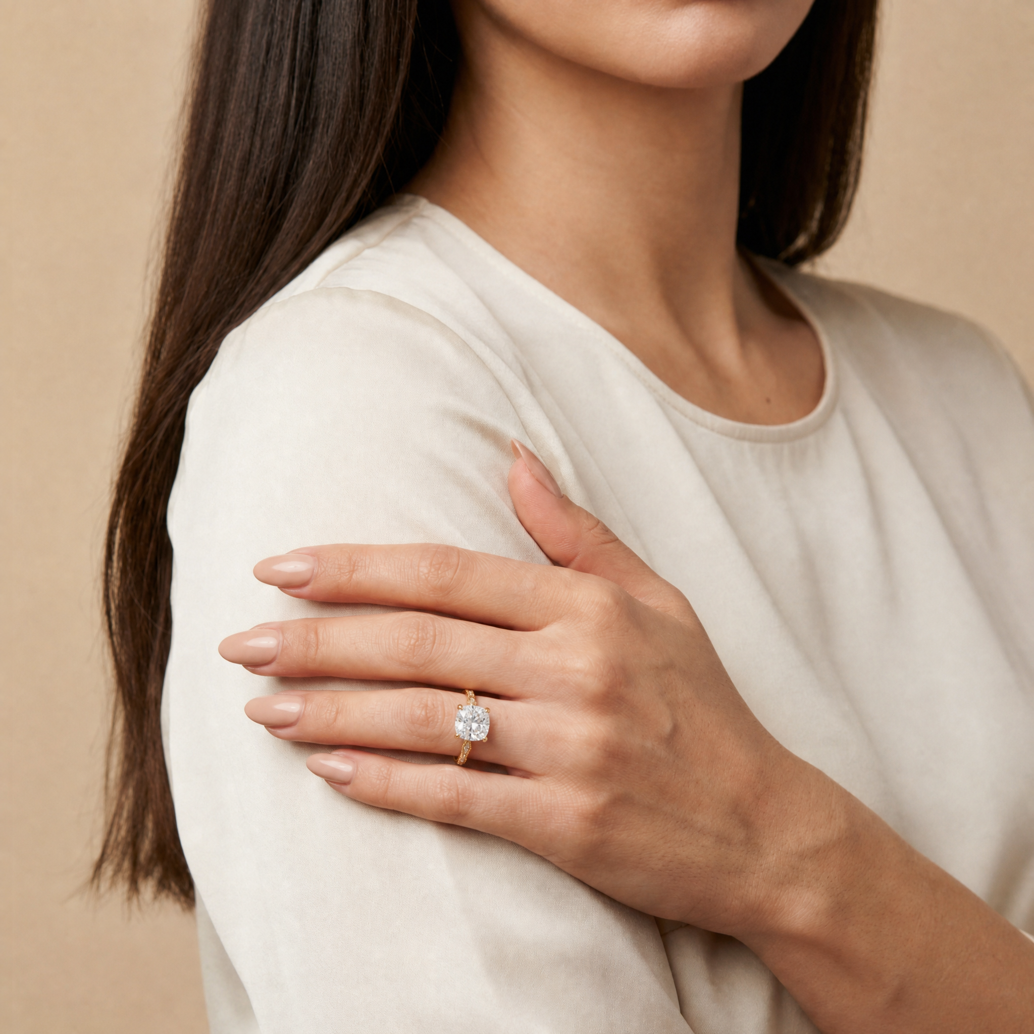 Model wearing Raul Diamonds cushion cut lab grown diamond engagement ring in 14K gold with elegant twisted pavé band