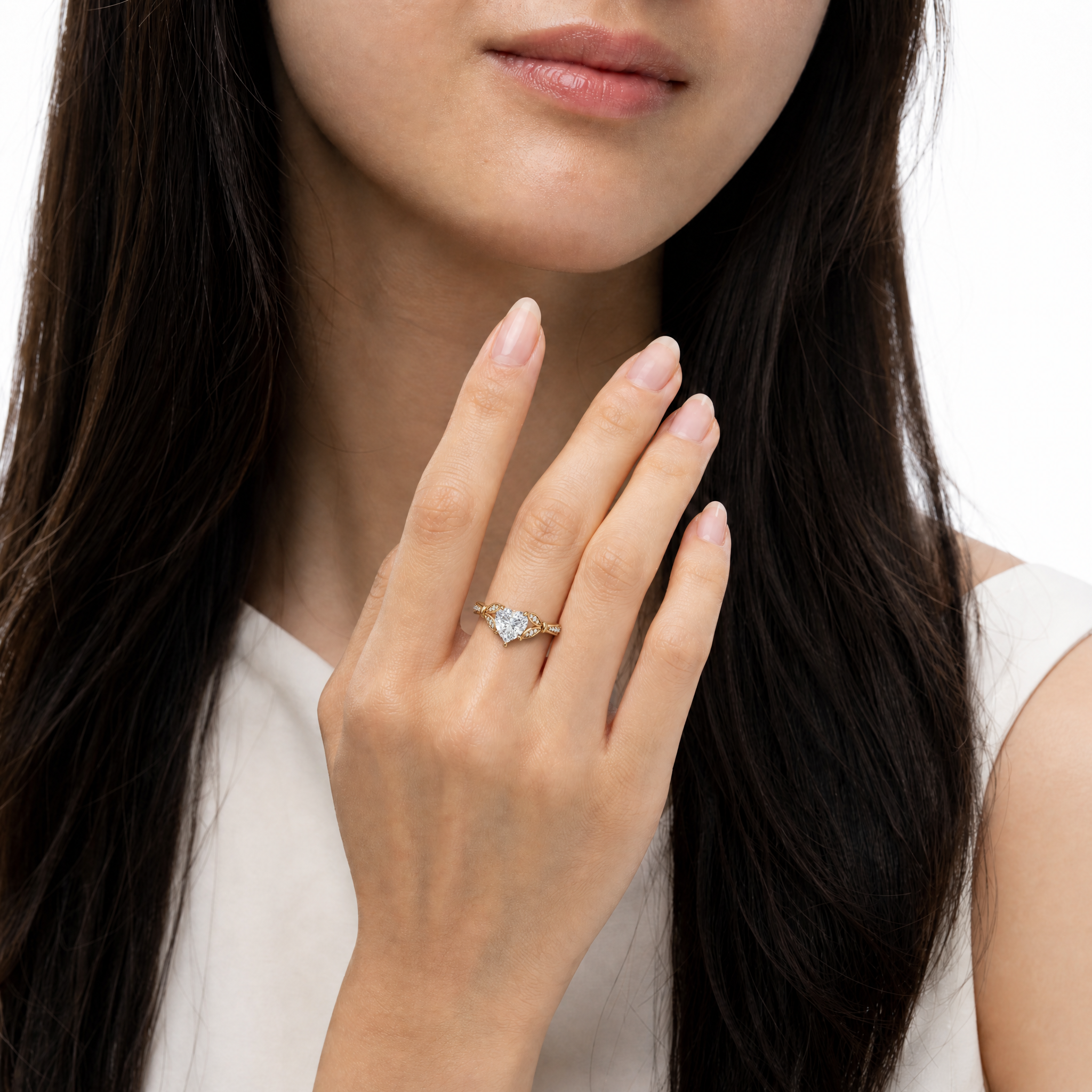 Model wearing Raul Diamonds heart cut lab grown diamond engagement ring in 14K gold with romantic pavé detailing