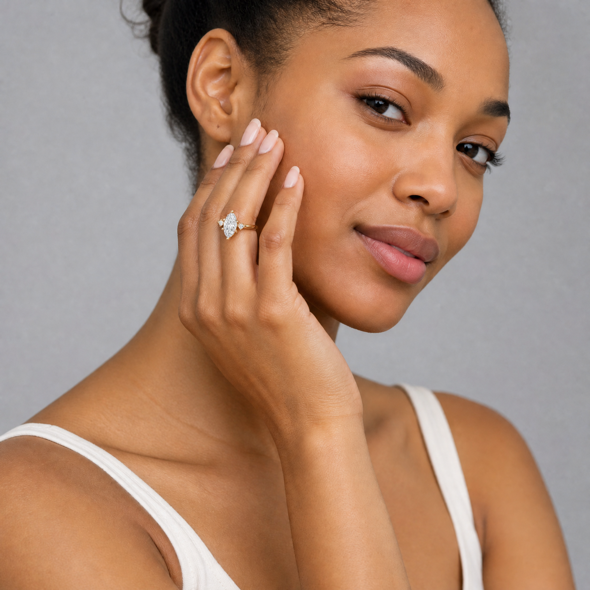 Model wearing Raul Diamonds marquise cut lab grown diamond engagement ring in 14K yellow gold with round side stones