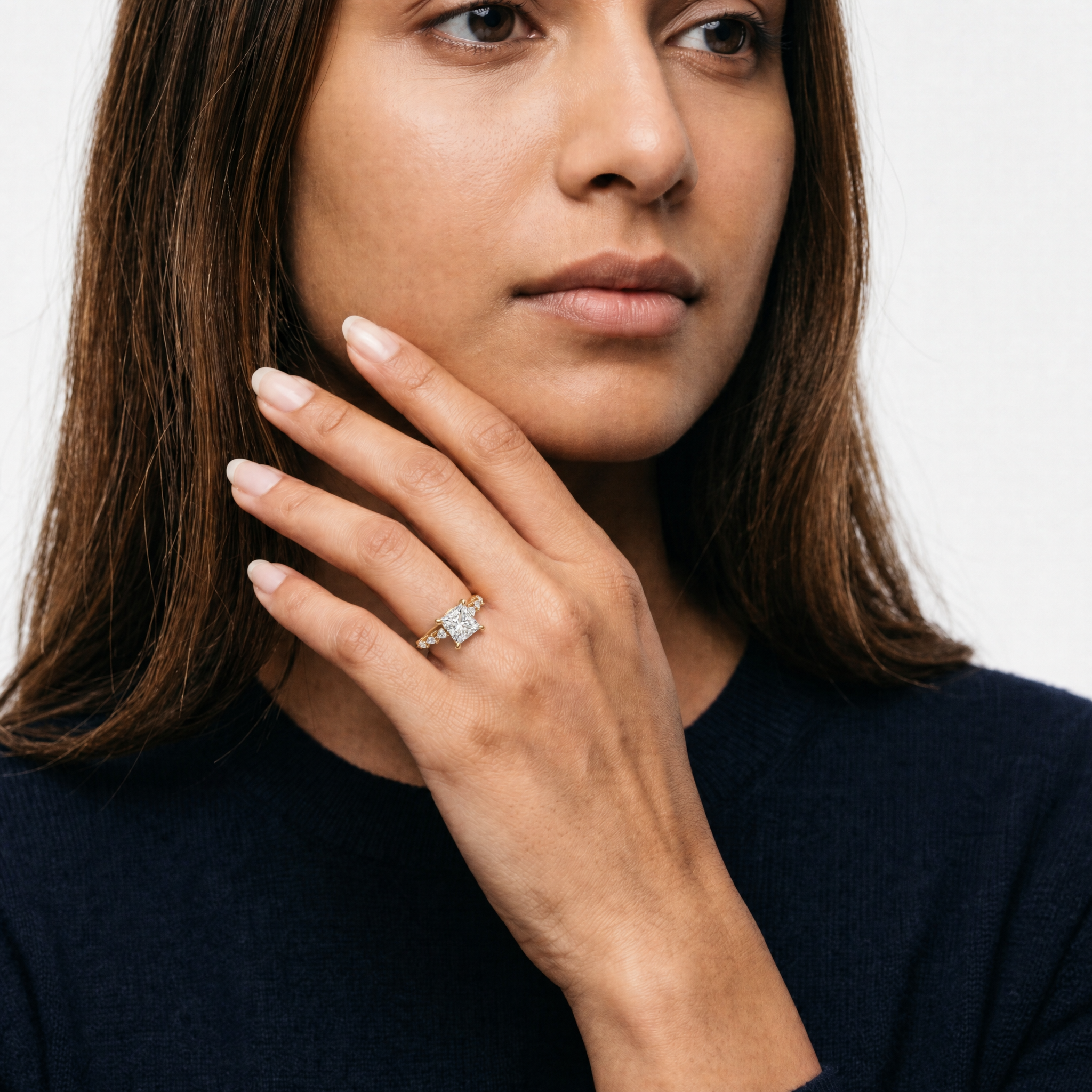 Model wearing princess cut lab grown diamond engagement ring in 14K gold with marquise side stones by Raul Diamonds