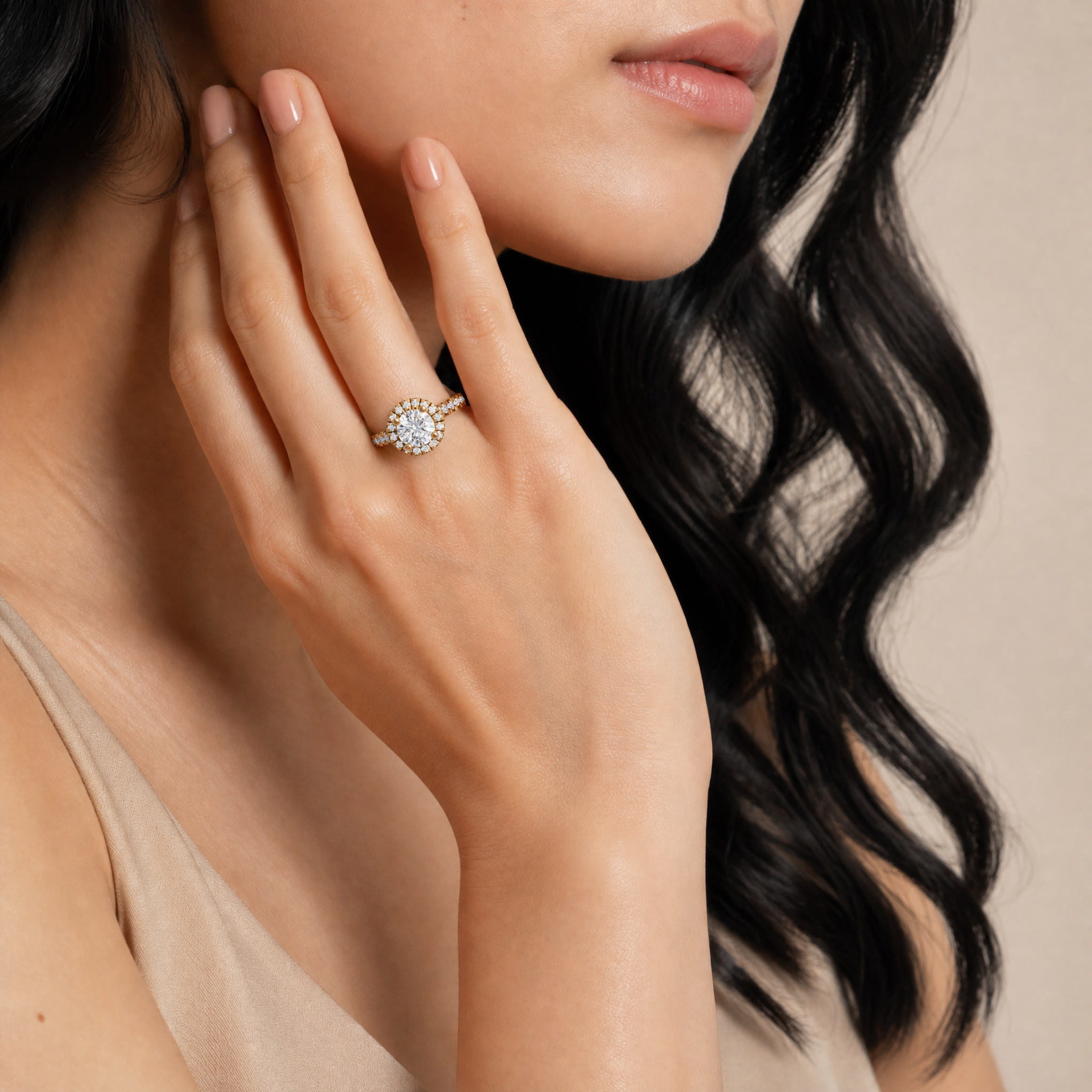 Woman wearing Raul Diamonds round halo engagement ring with pavé diamond band in yellow gold.