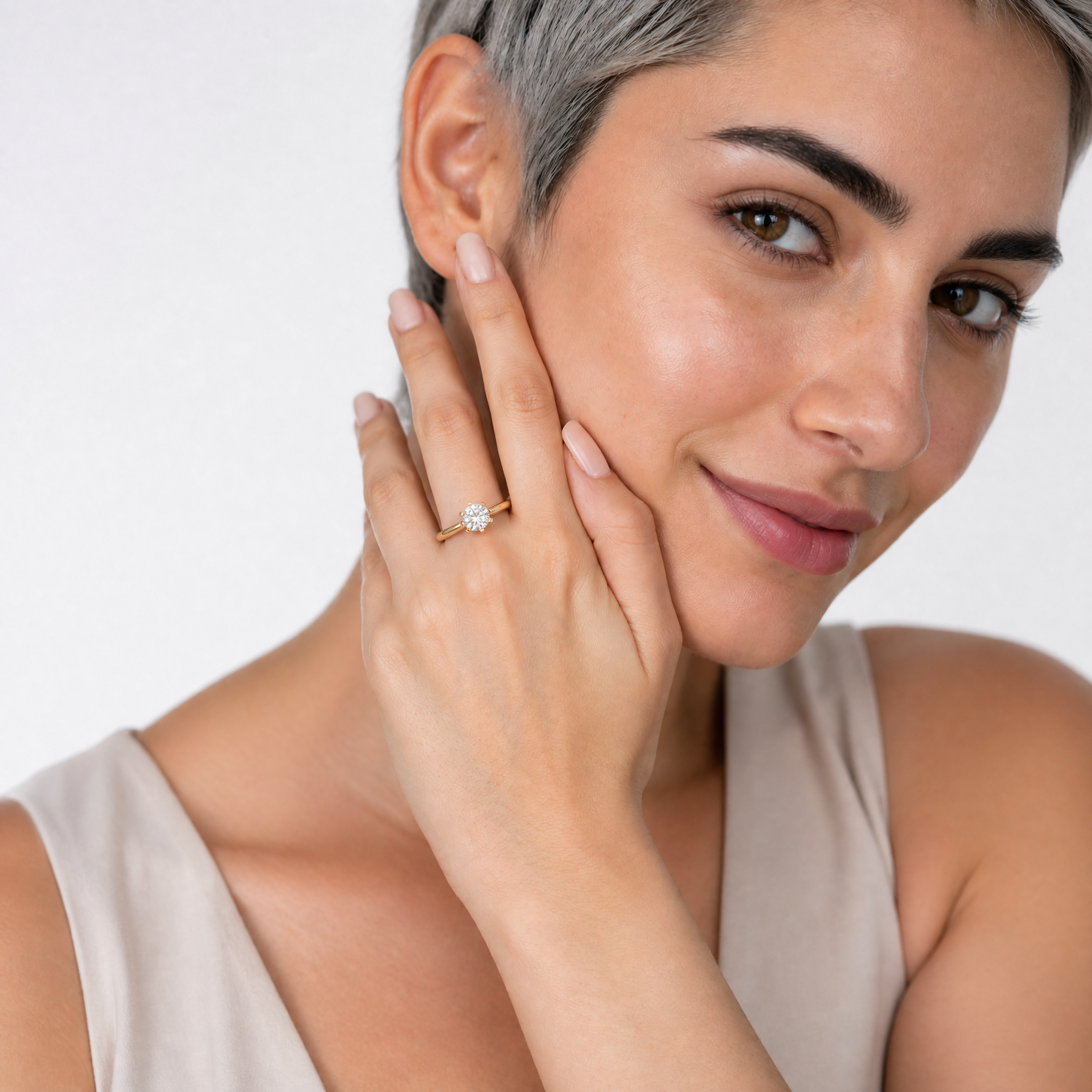 Model wearing Raul Diamonds classic round solitaire diamond engagement ring in polished yellow gold.