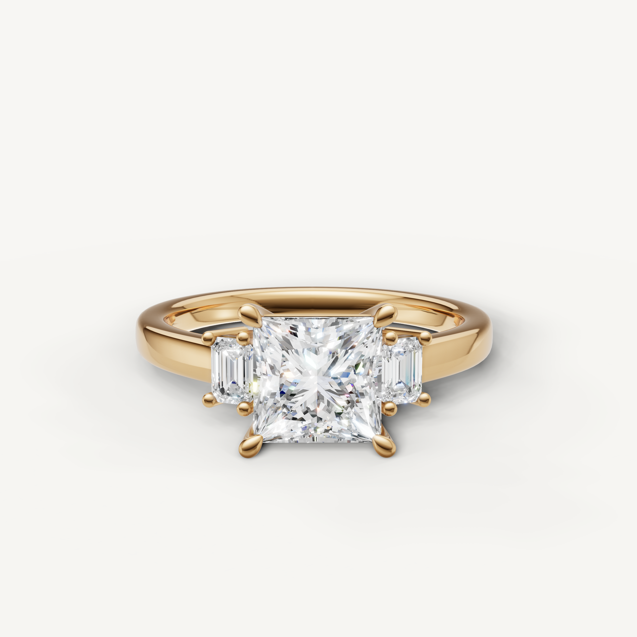 Princess cut lab grown diamond three stone engagement ring in 14K yellow gold with emerald cut side stones