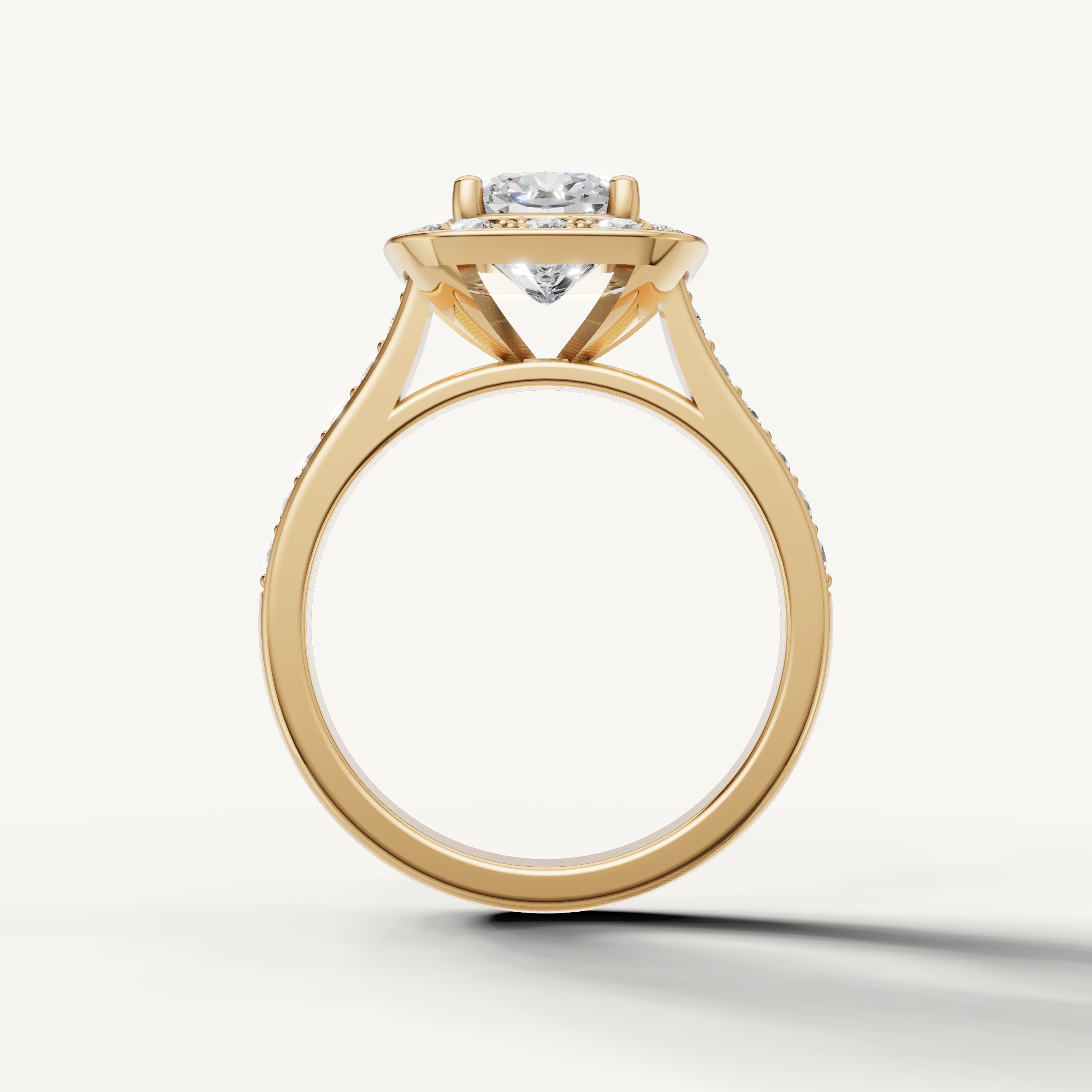 Cushion cut diamond engagement ring in yellow gold with halo detailing by Raul Diamonds.