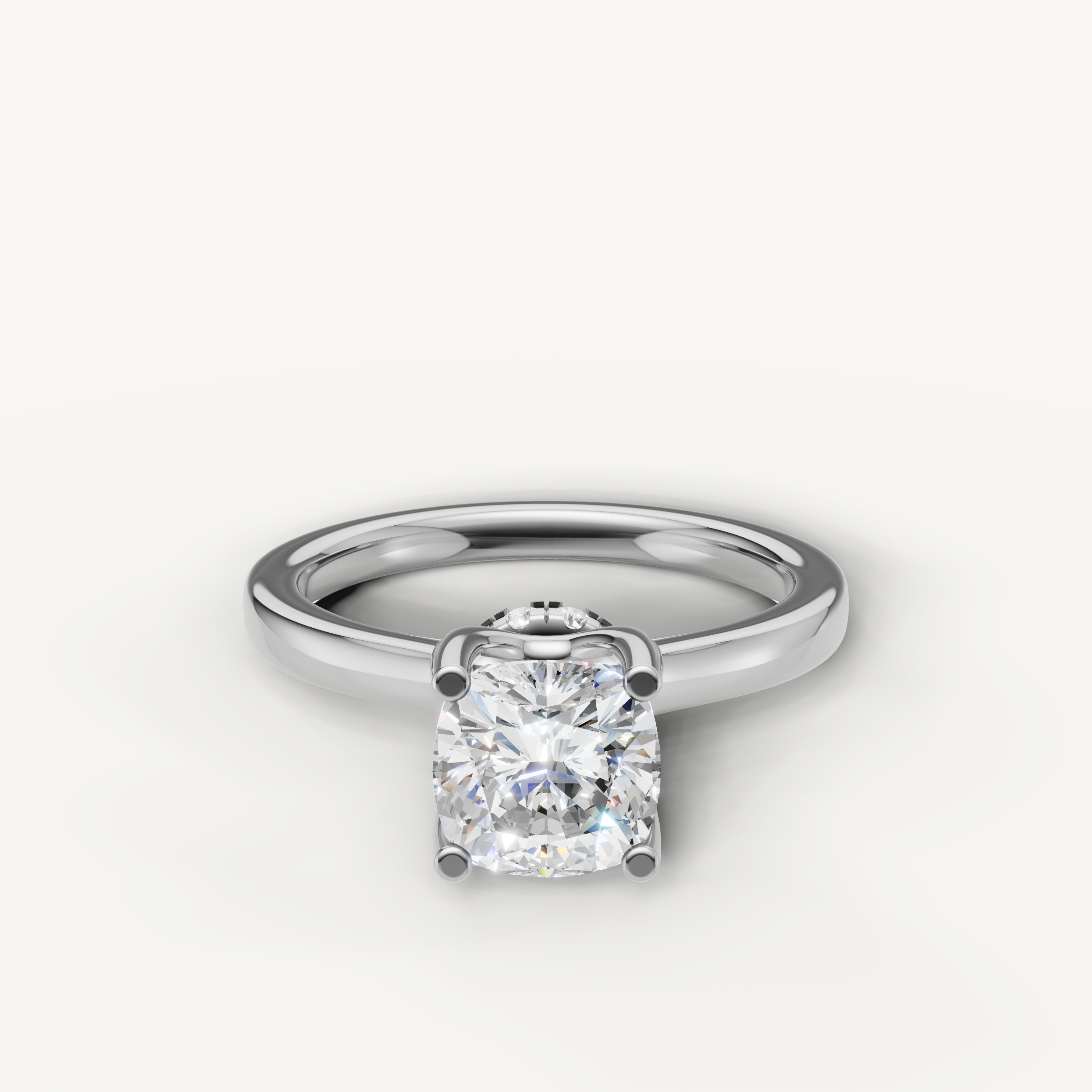 A classic solitaire ring in polished white gold or platinum, featuring a brilliant cushion-cut diamond set in four secure prongs.