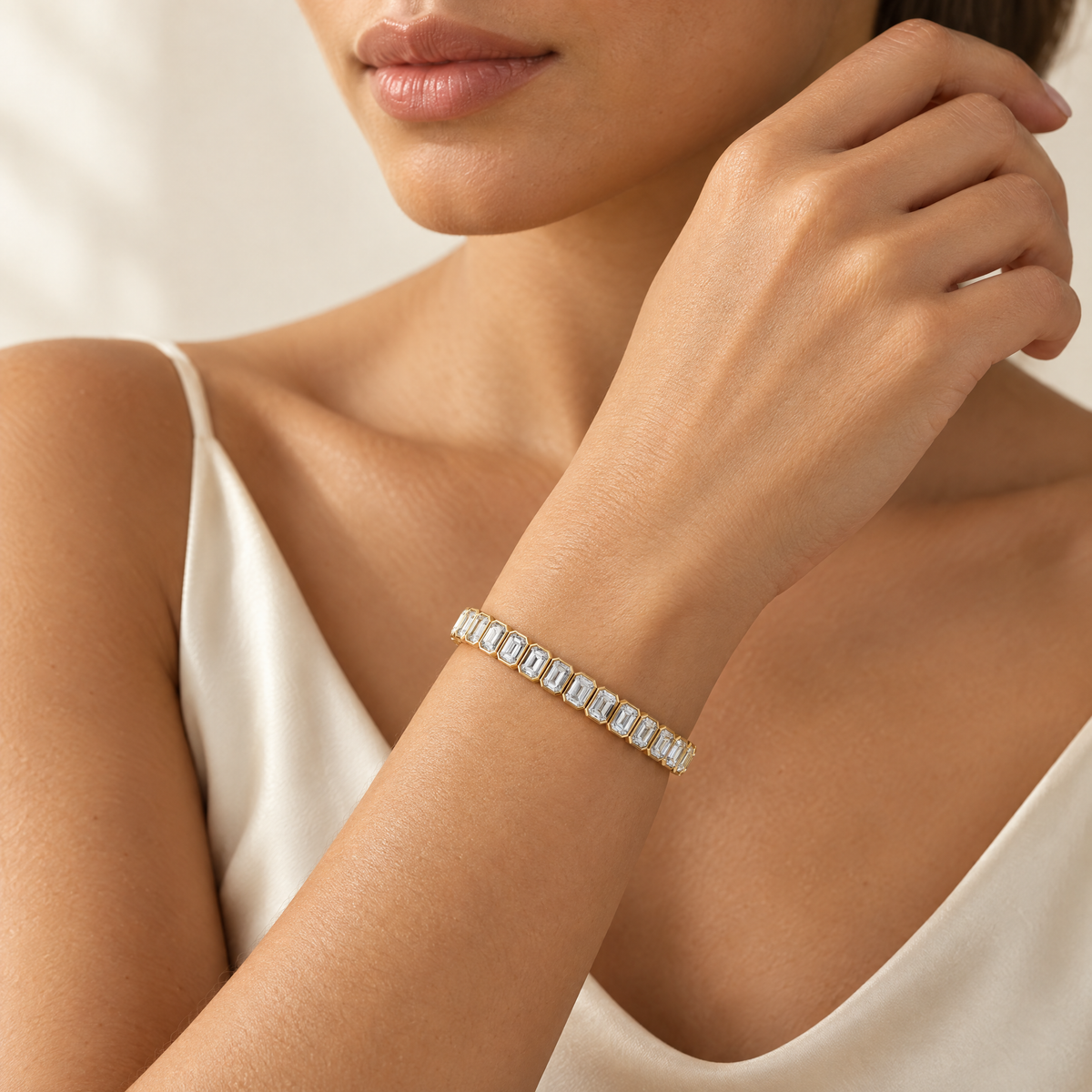 Emerald cut lab-grown diamond tennis bracelet in 14K yellow gold worn on the wrist