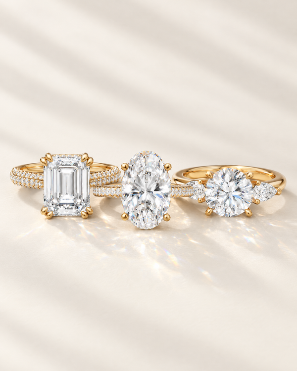 Lab-grown diamond engagement rings in emerald, oval and round three-stone styles, 14K yellow gold