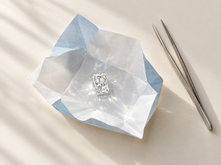 Loose radiant cut lab-grown diamond on an opened diamond parcel paper