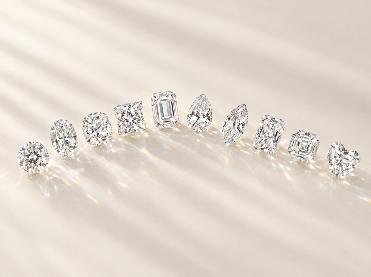 Ten loose lab-grown diamonds in different shapes arranged in an arc
