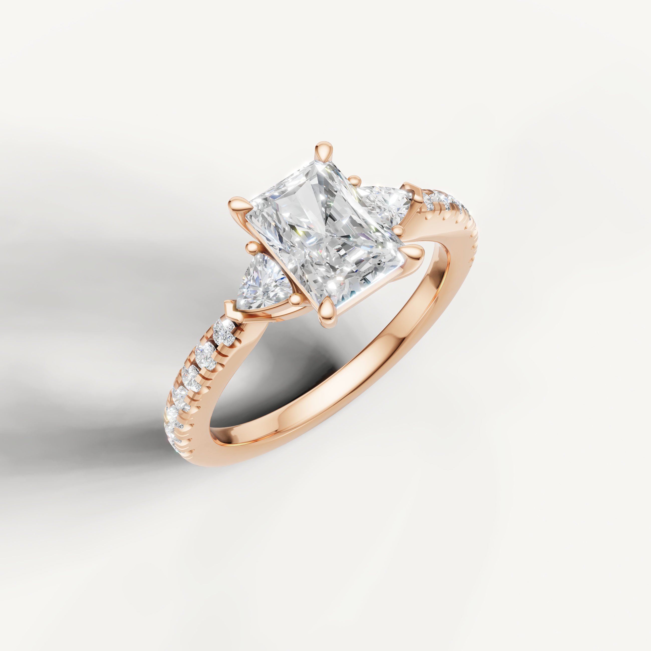 Modern radiant cut three-stone lab grown diamond ring in yellow gold with pavé band