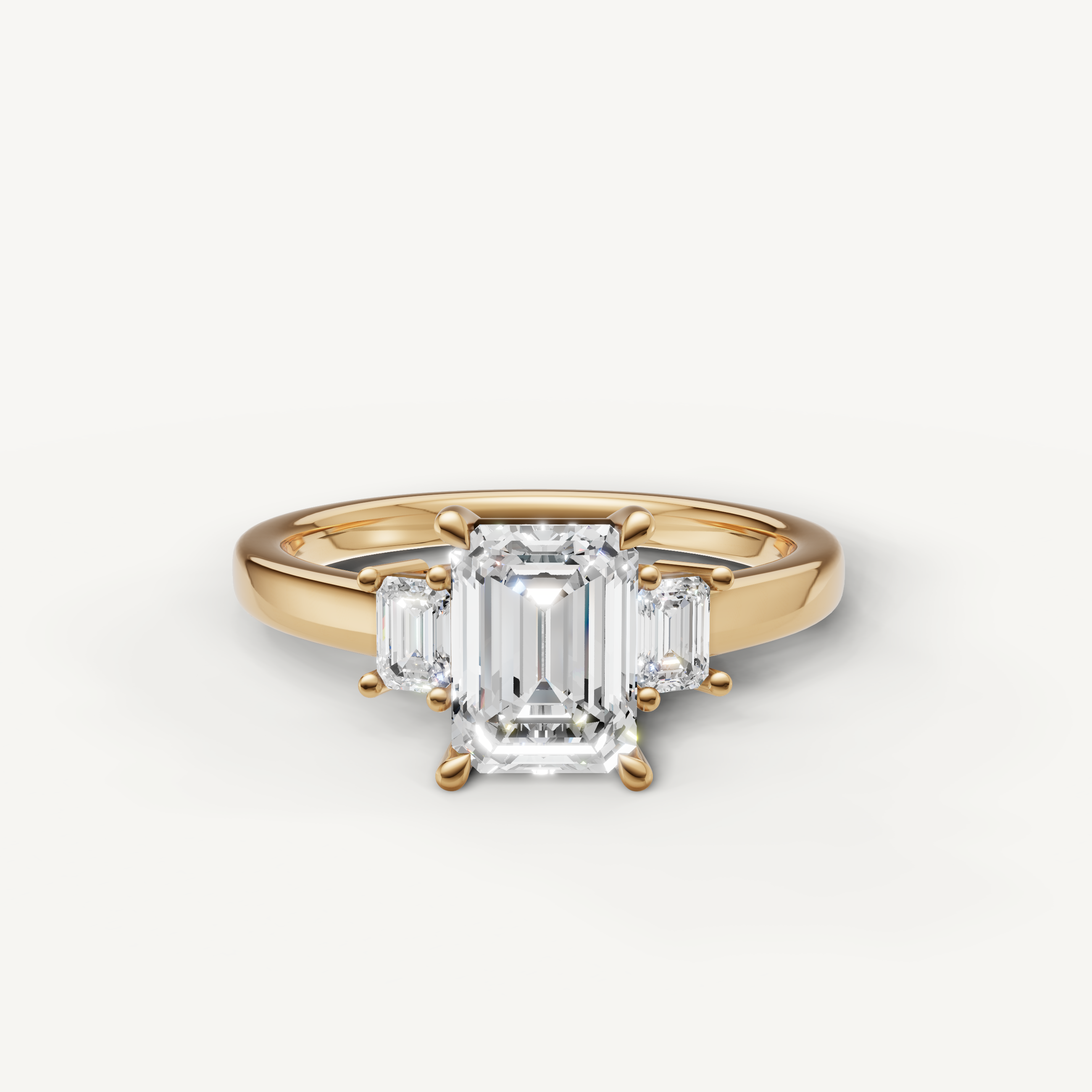 Emerald cut lab grown diamond three stone engagement ring in 14K yellow gold with step cut side stones