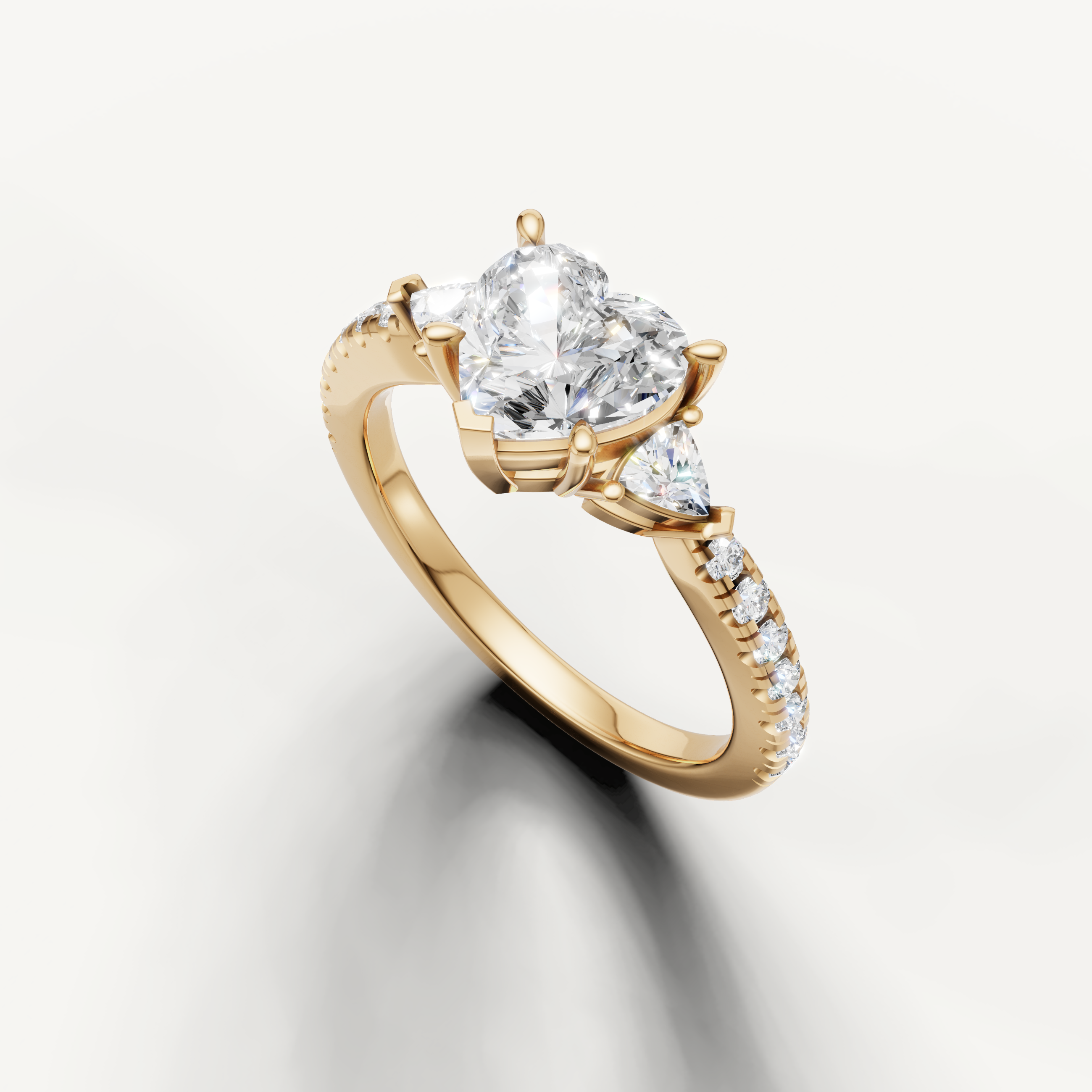 Heart cut three-stone lab grown diamond engagement ring with pavé band in yellow gold