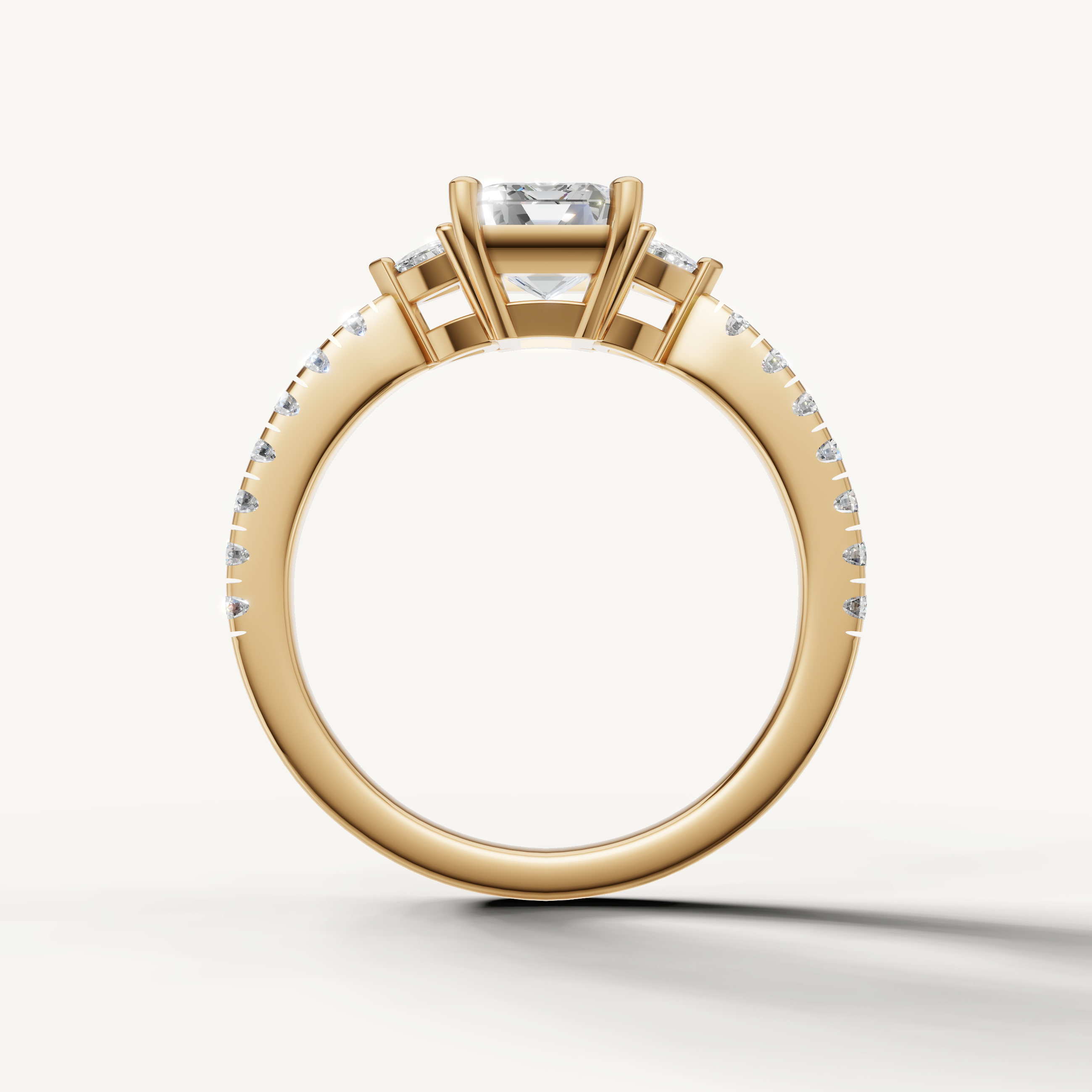 Angled view of 14K yellow gold emerald cut engagement ring with side stones and pavé band