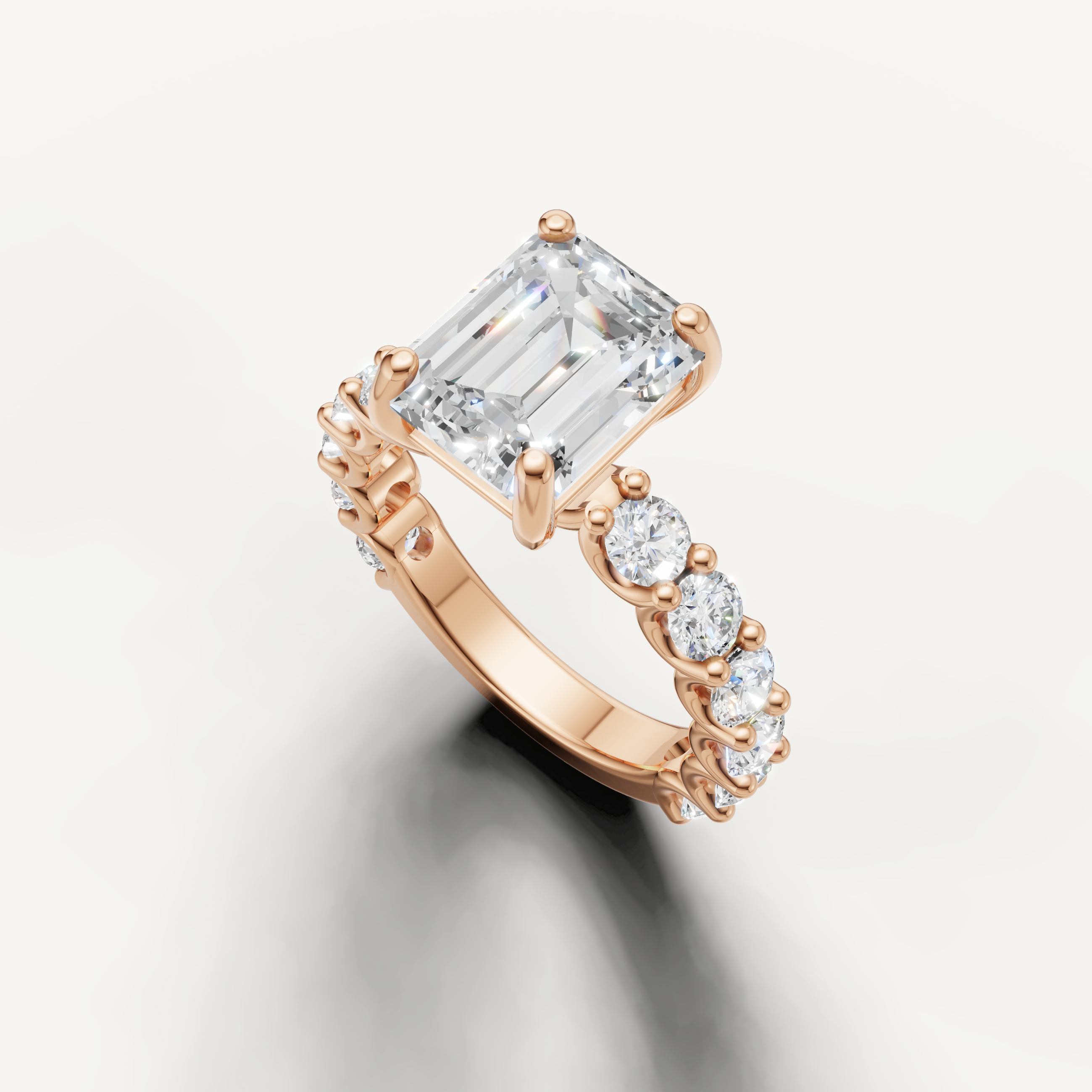 Emerald cut solitaire ring with graduated side stones in rose gold