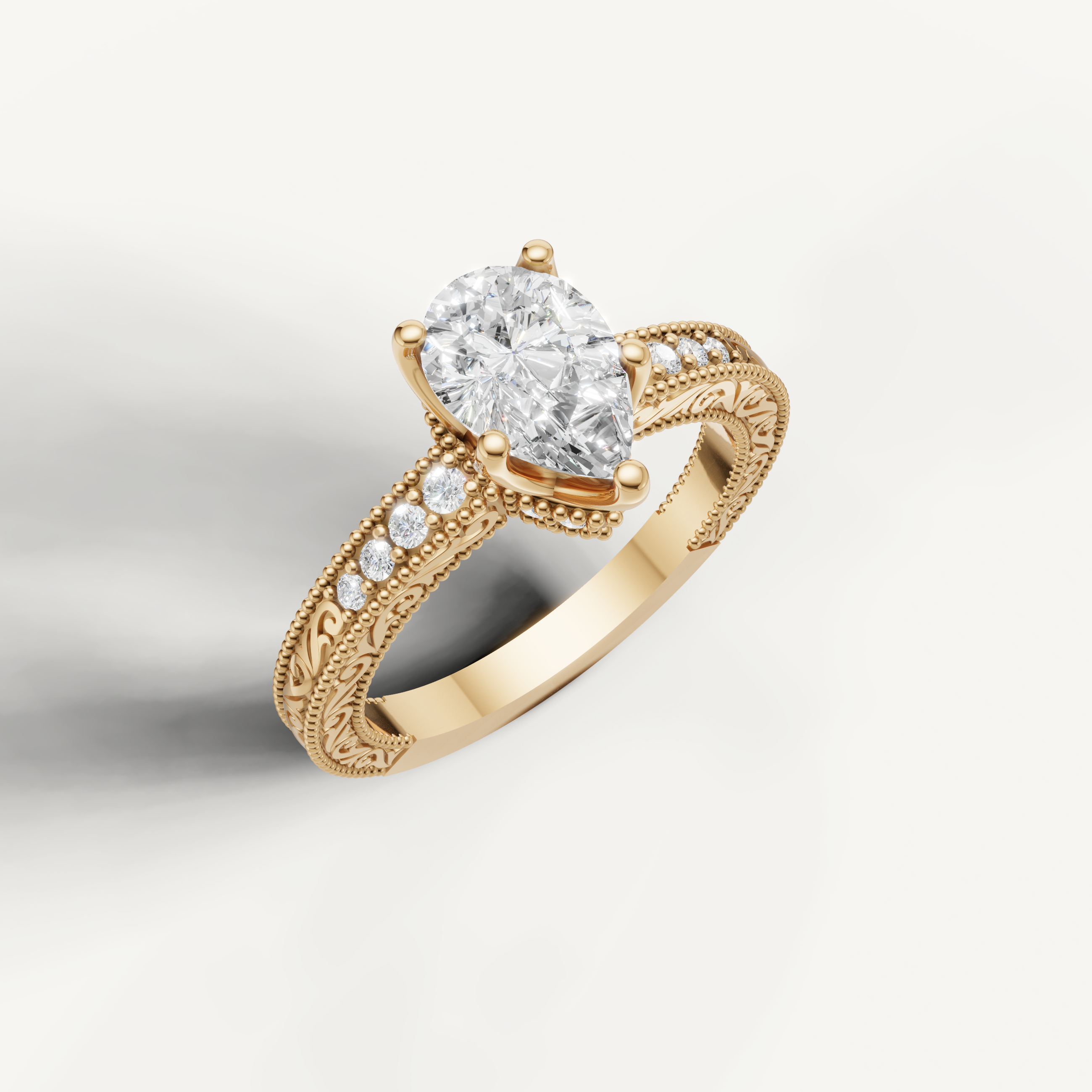 Elegant vintage-style pear diamond engagement ring with decorative yellow gold detailing and round side diamonds from Raul Diamonds.