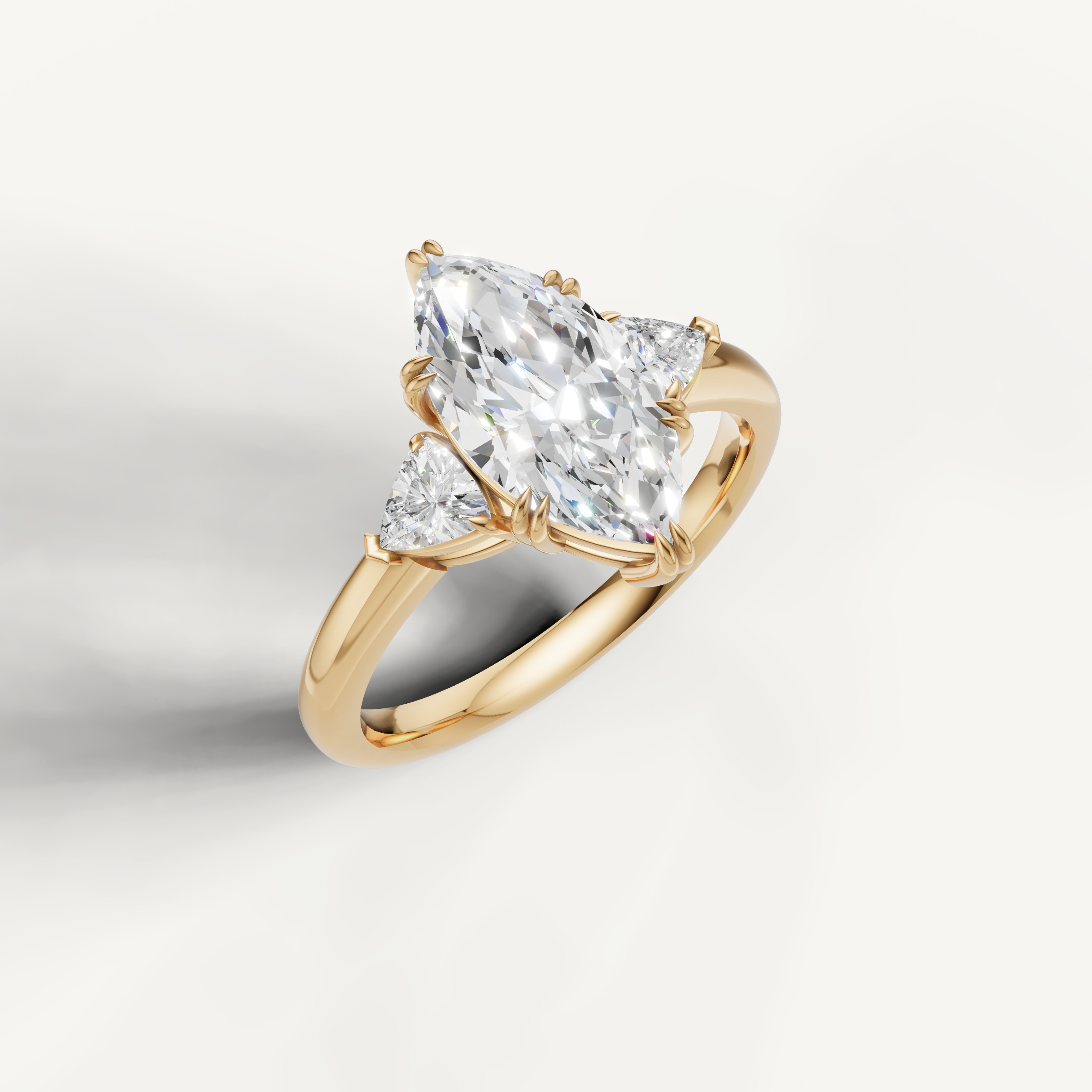 elongated marquise lab grown diamond trilogy ring with brilliant trillion accents in yellow gold
